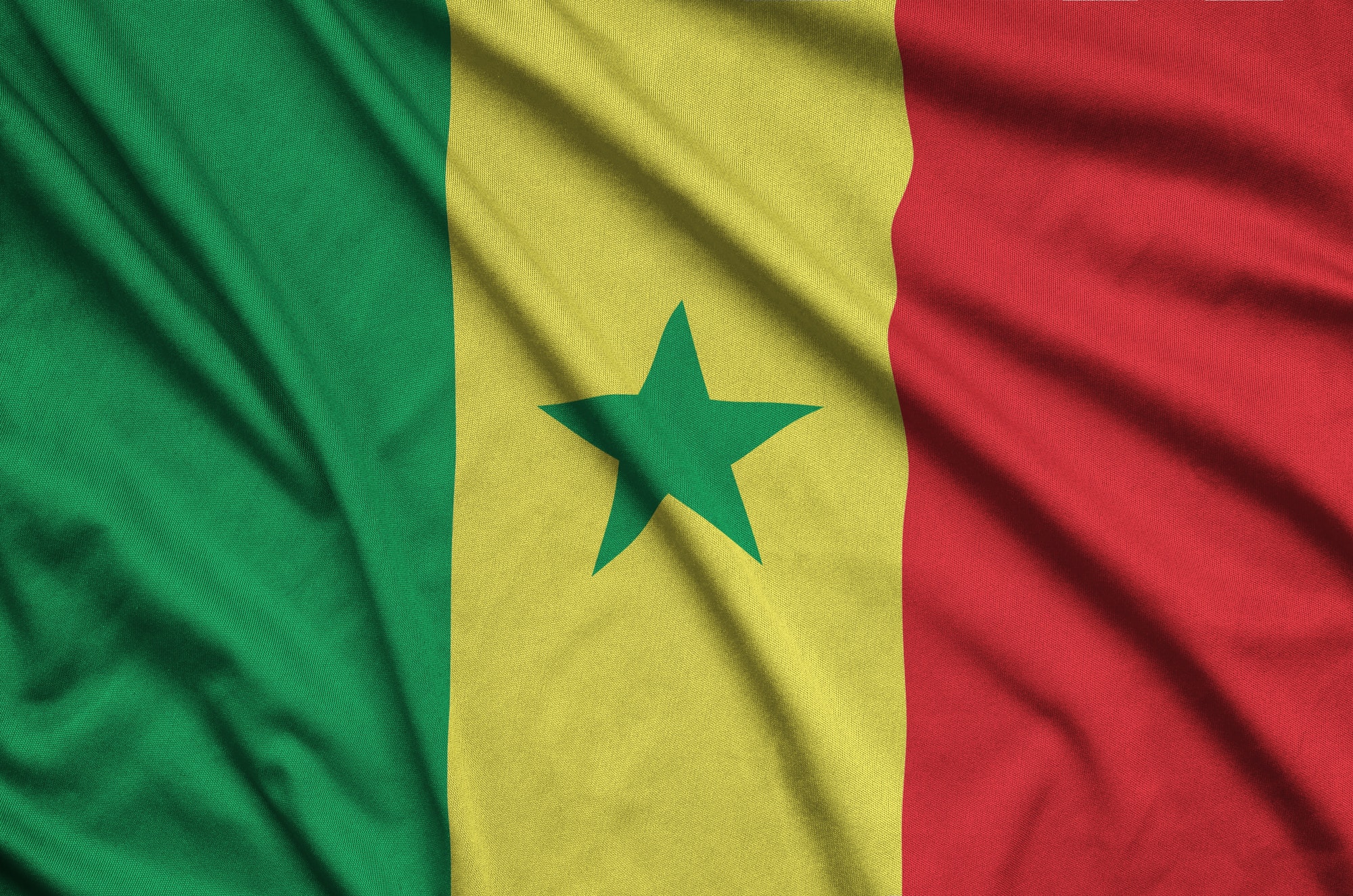 Senegal flag is depicted on a sports cloth fabric with many folds. Sport team waving banner